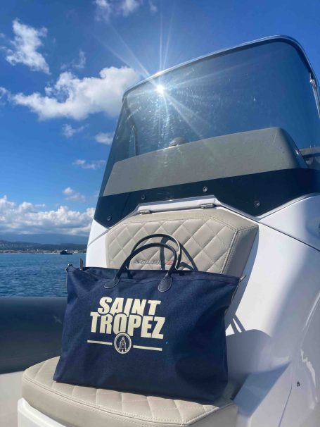 Sac bleu marine "Saint Tropez" sur un siège de bateau, avec un ciel ensoleillé.
